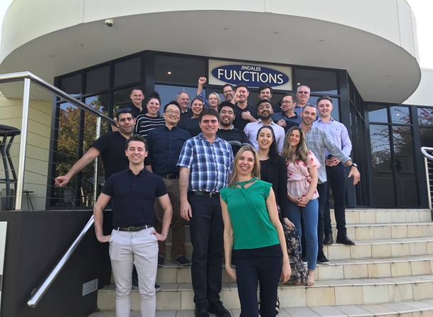 A Dale Carnegie class group photo on the steps under the Jindalee Functions sign